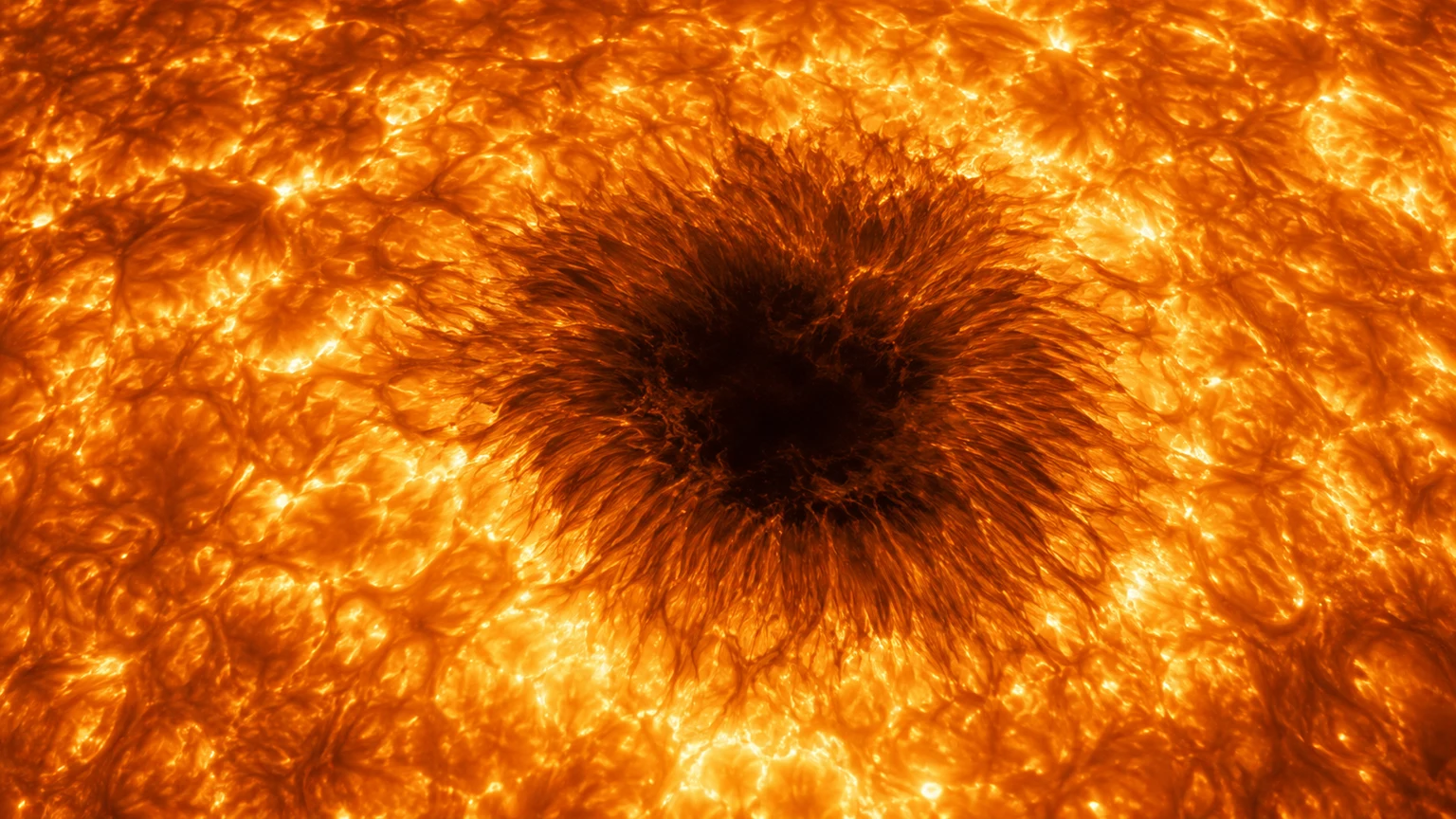 A hypothetical cooler magnetic patch surrounded by luminous convection. The pattern is invented; dark regions are plasma, not solid ground.