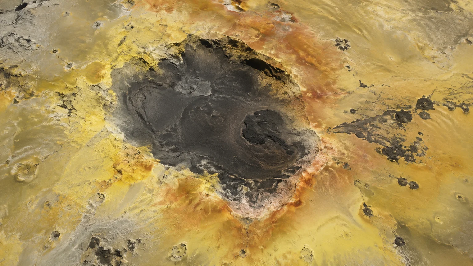 A dark volcanic depression with muted yellow sulfur-stained deposits and reddish diffuse margins, tiny dark lava lobes. An artistic reconstruction of Io; local detail, lighting and viewpoint are imagined.