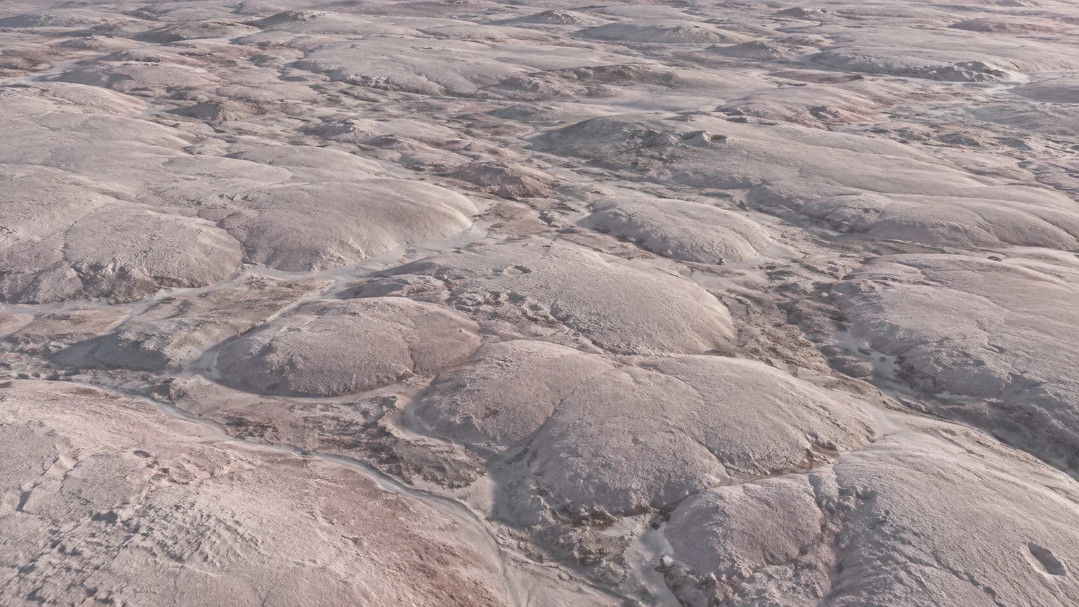Muted pale pink-gray hummocky cells and shallow irregular troughs. An artistic reconstruction of Triton; local detail, lighting and viewpoint are imagined.
